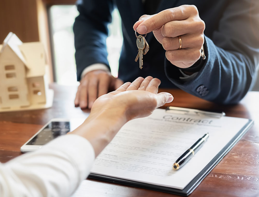 Real Estate Agent handing over keys after contract signing