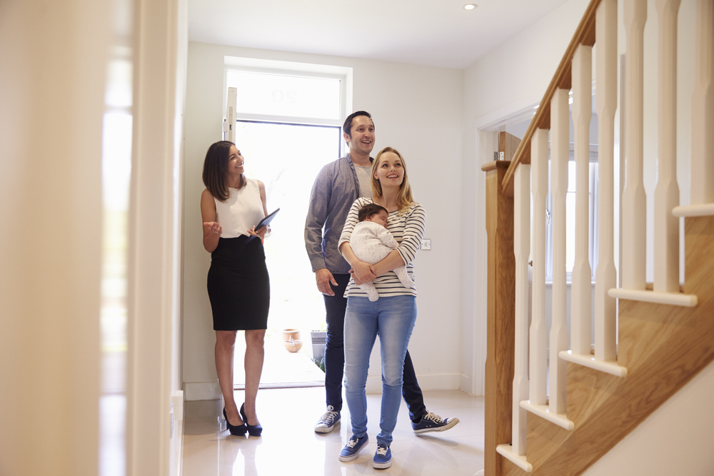 Realtor Showing Young Family Around Property For Sale