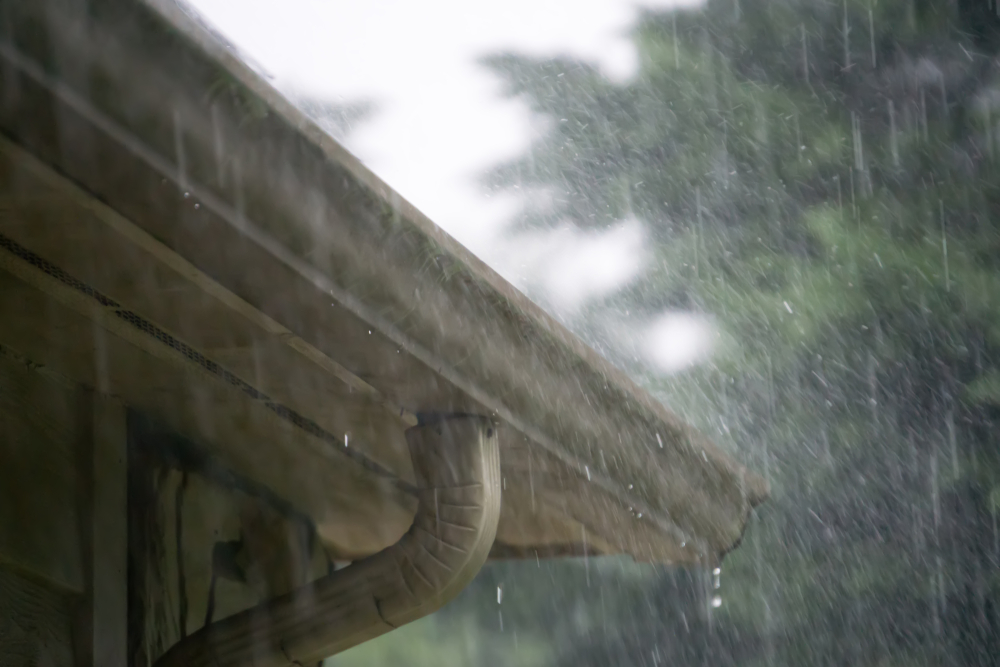 heavy rain pouring down from passing storm - gutters on house