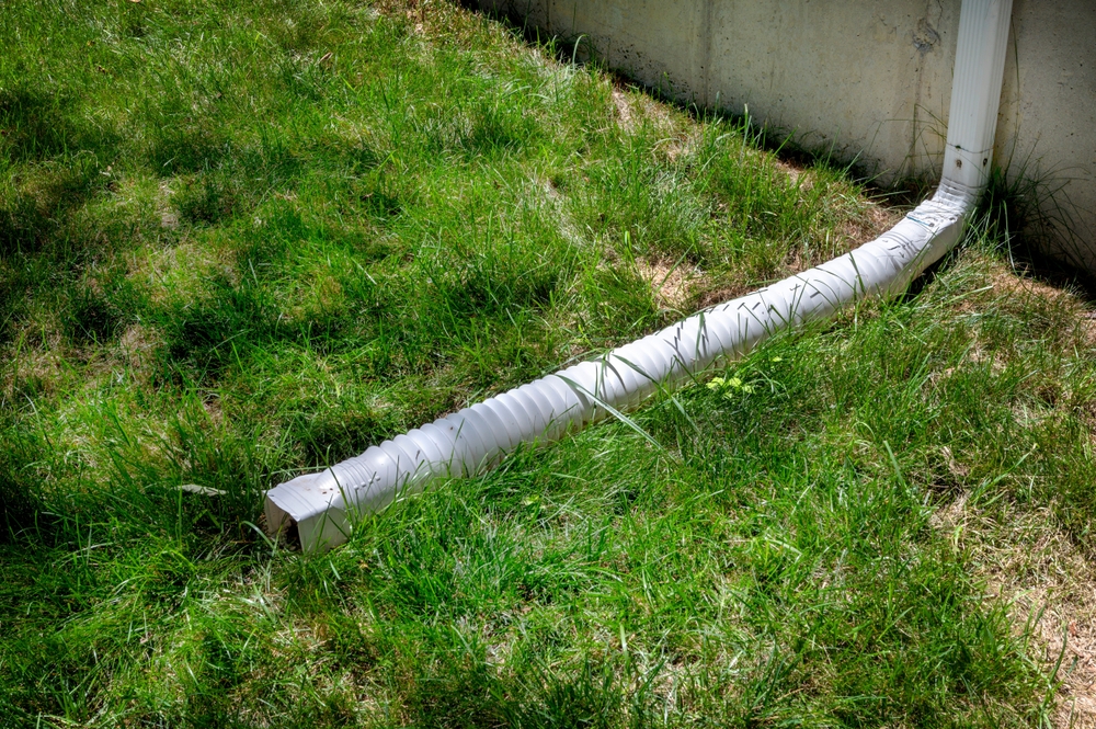 Gutter downspout, flexible rain gutter extension next to house wall