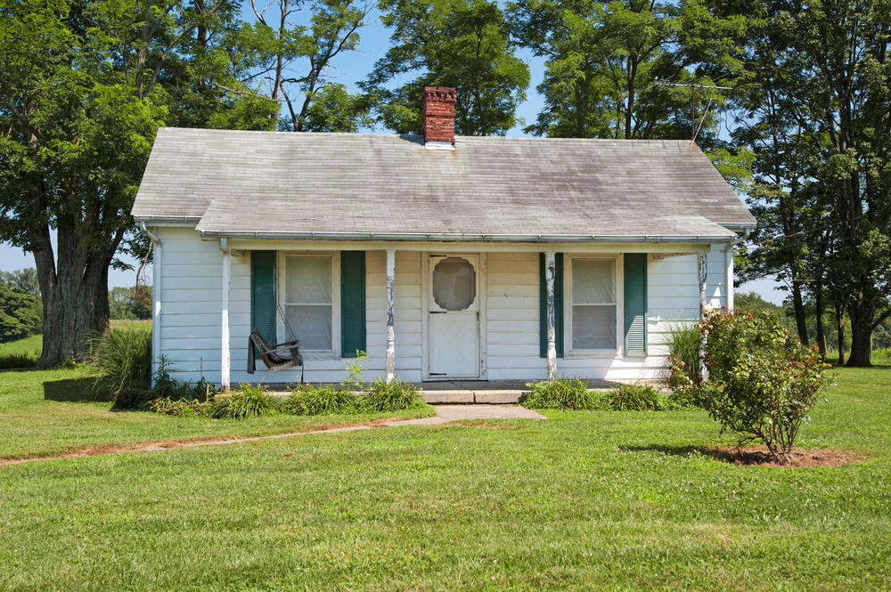 A wood siding house that a realtor would refer to as a fixer-upper